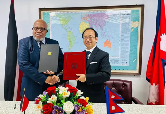 Permanent Representative of Nepal to the UN Amrit Bahadur Rai and Ambassador of Trinidad & Tobago to the UN Dennis Francis exchanging signed document to establish diplomatic relations between the two countries in New York Friday.